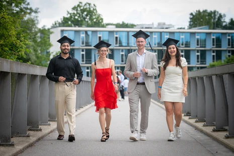 Absolventinnen und Absolventen der Life Sciences überqueren die TUM-Brücke in Weihenstephan.